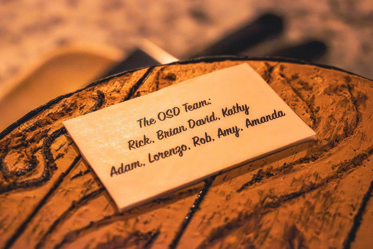 A handwritten card from the OSD team on a wooden table